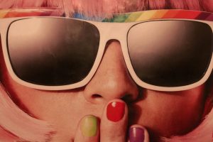 female with sunglasses and colourful nails